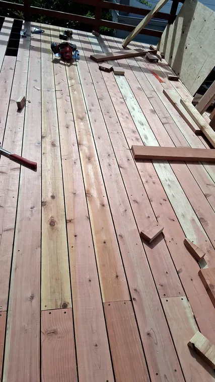 Deck boards being repaired with tools and lumber visible