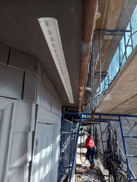 Worker on scaffolding during residential exterior construction
