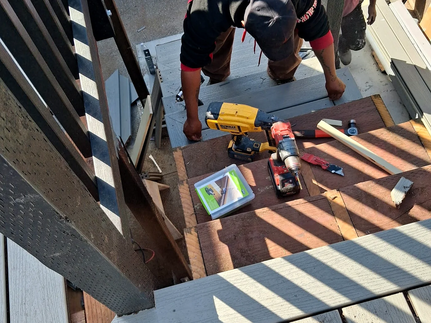 Carpenters installing boards on an exterior stair and deck